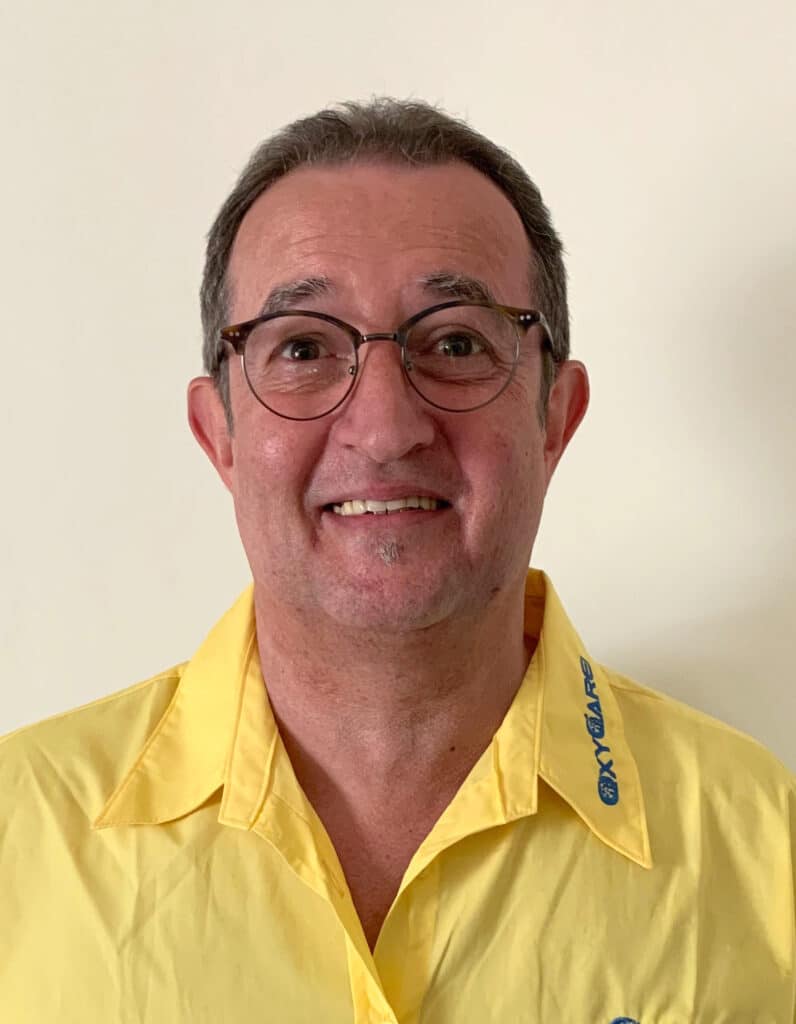 Foto von Matthias Bonnemann, Mitarbeiter von OxyCare. Er trägt ein gelbes Hemd mit dem OxyCare Logo und schaut freundlich in die Kamera.