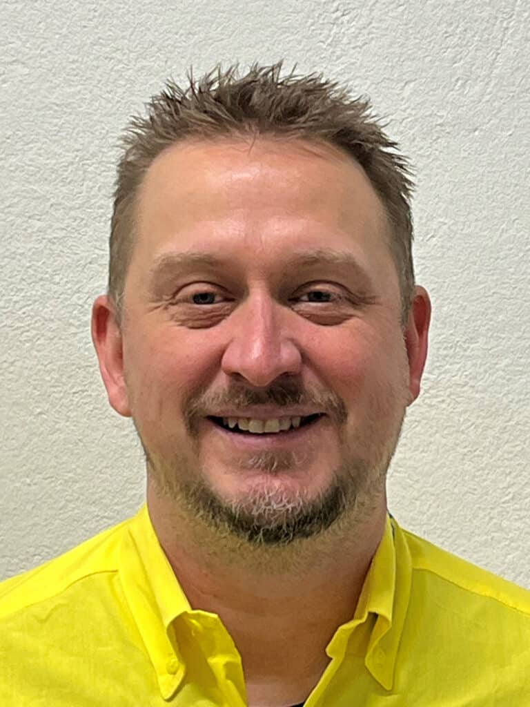 Foto von Marc Styppa, Mitarbeiter von OxyCare. Er trägt ein gelbes Hemd mit dem OxyCare Logo und schaut freundlich in die Kamera.